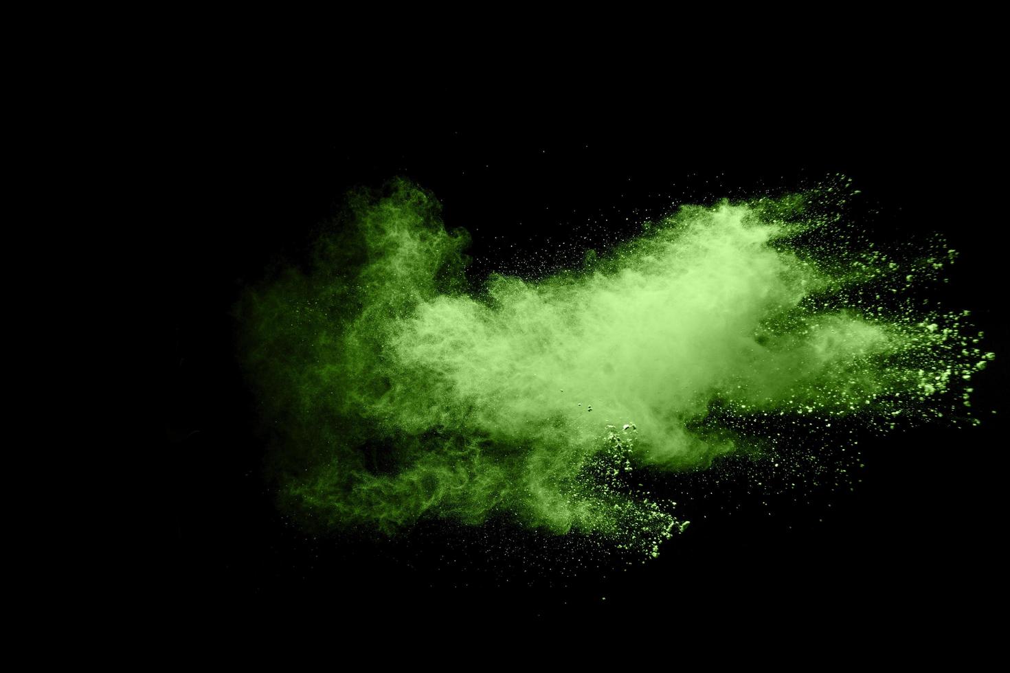 Abstract green dust explosion on black background. photo