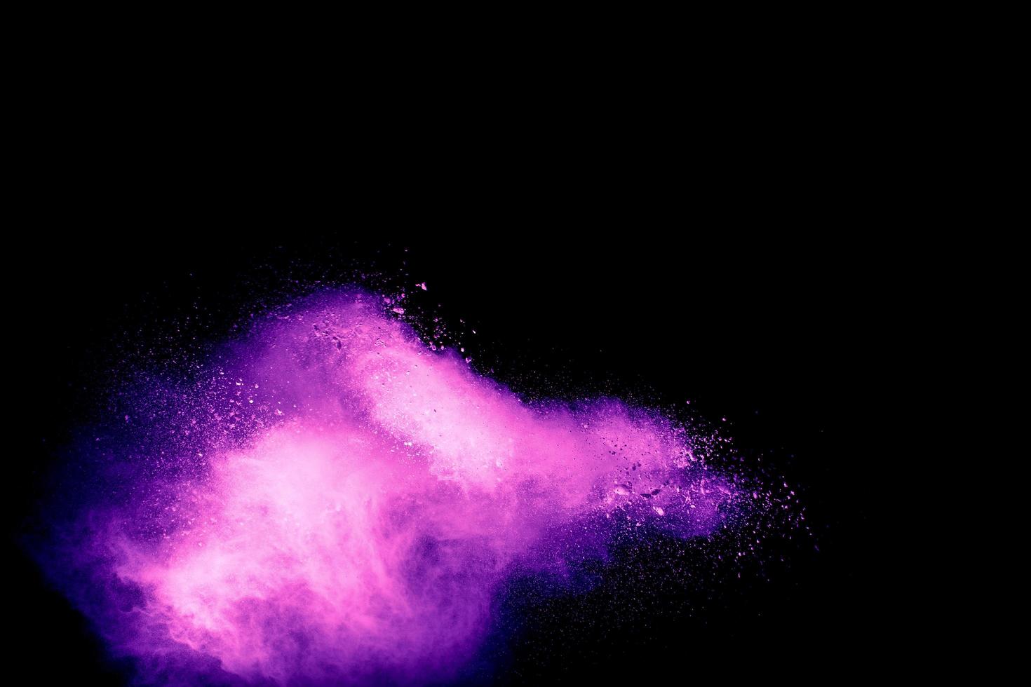 Pink dust particles splash on black background.Pink powder splash. photo