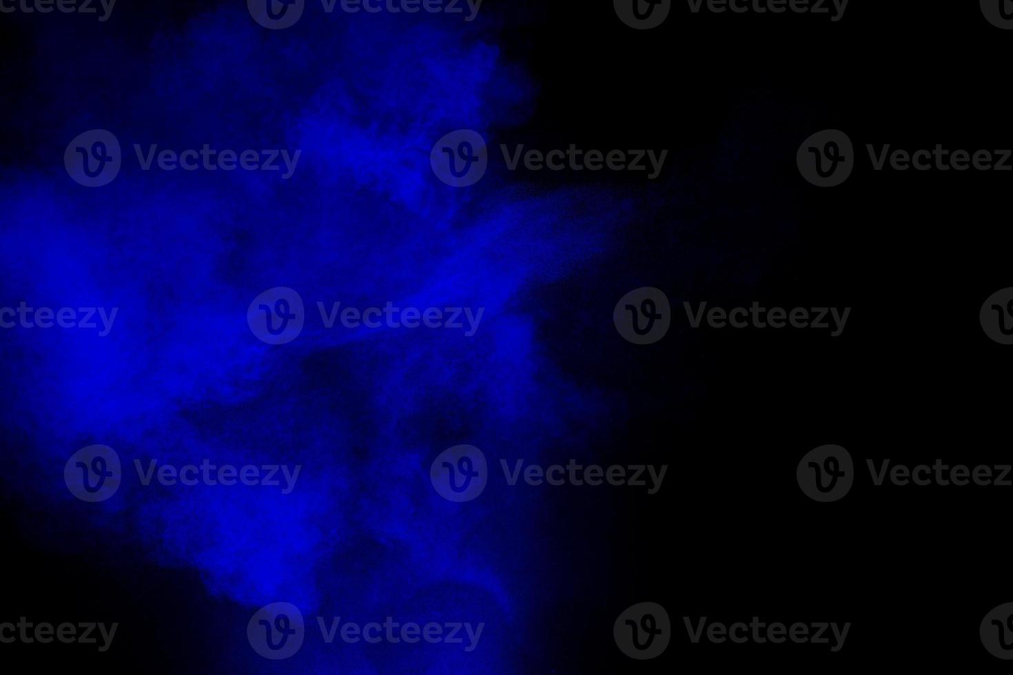 Abstract blue  powder explosion cloud  on dark background. photo