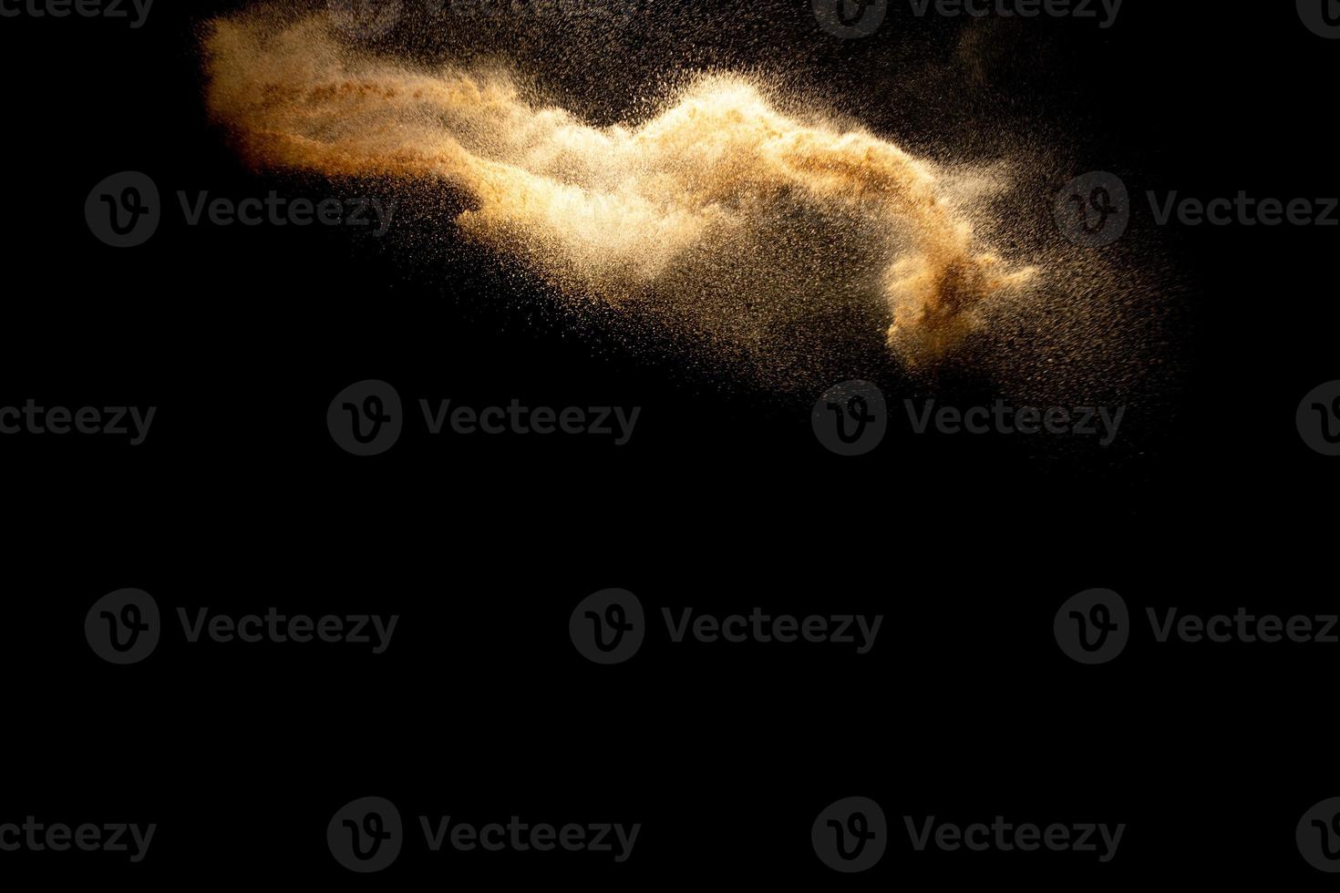Abstract motion blurred brown color sand splash against black background. photo