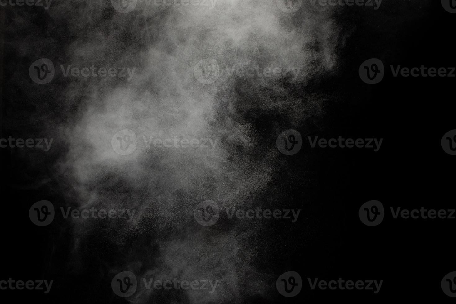 nube de explosión de polvo blanco sobre fondo negro. salpicaduras de partículas de polvo blanco. foto