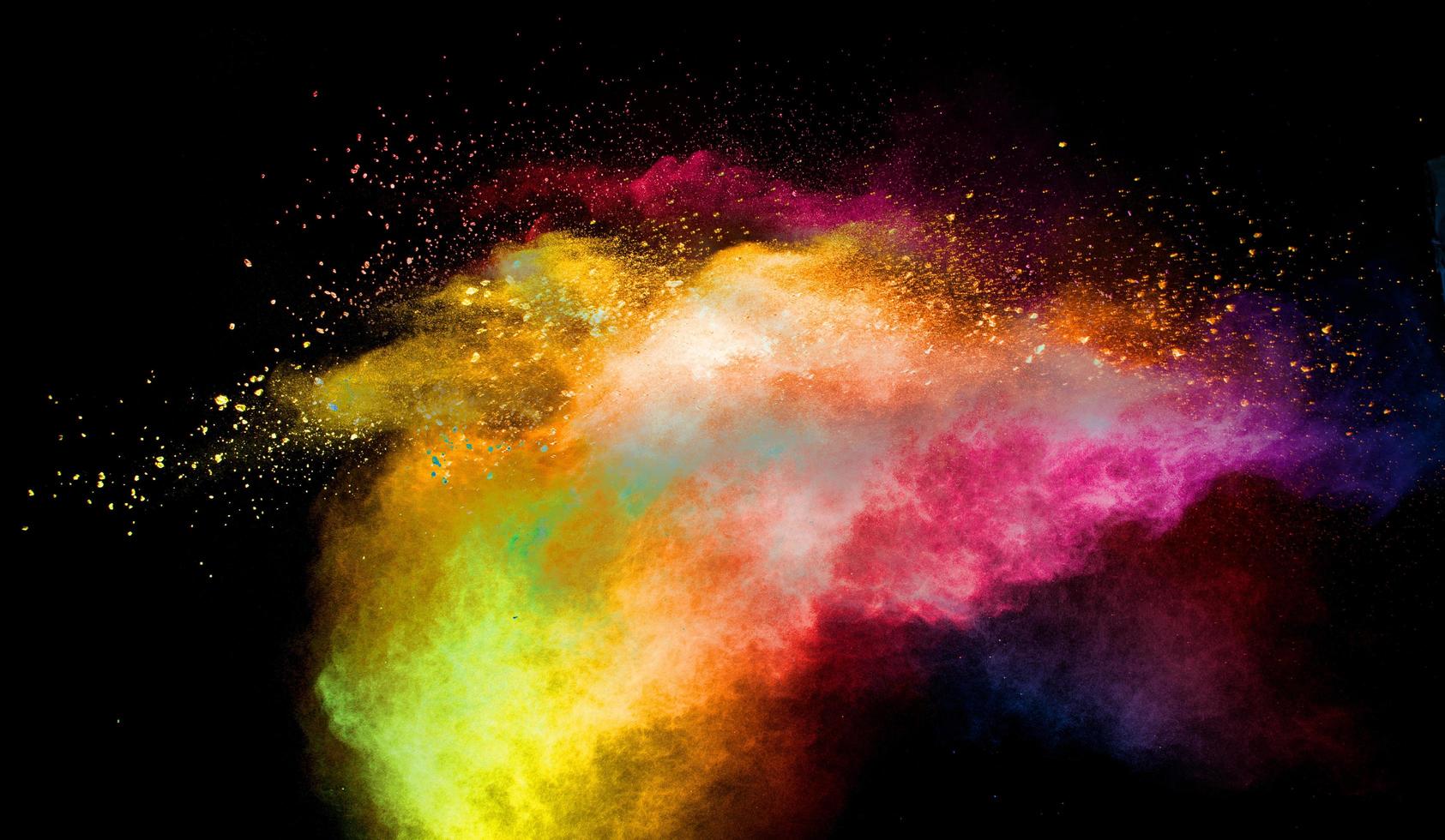 Multicolored powder explosion on black background.Colorful red yellow splash cloud on background. photo