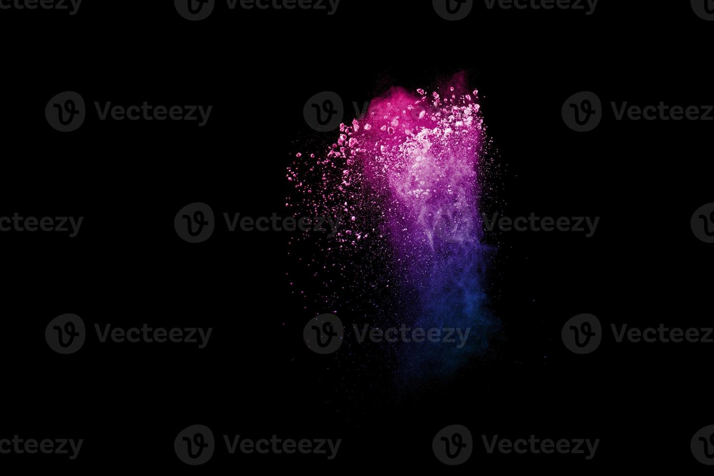 Freeze motion of colorful dust particles splash. Painted Holi powder. photo