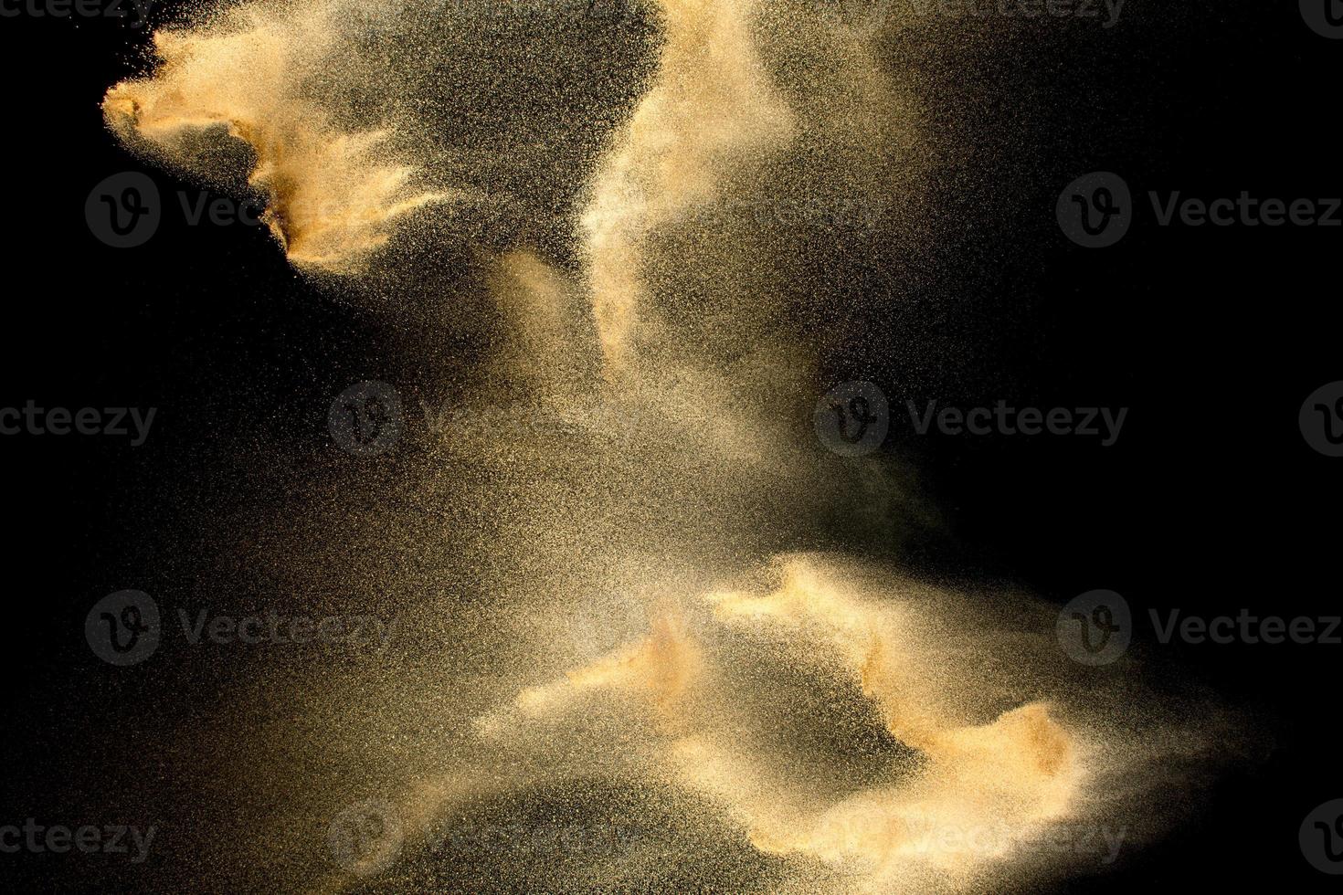Sand explosion isolated on black background. Freeze motion of sandy dust splash. photo