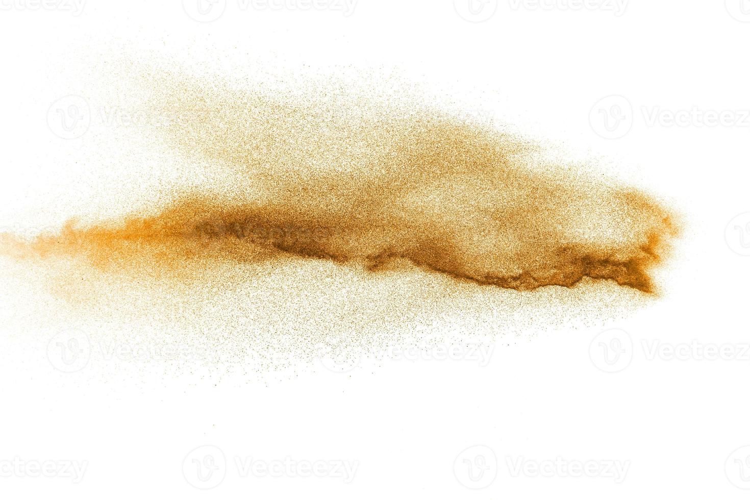 Abstract orange powder explosion on white background. Freeze motion of orange dust particles splash. photo