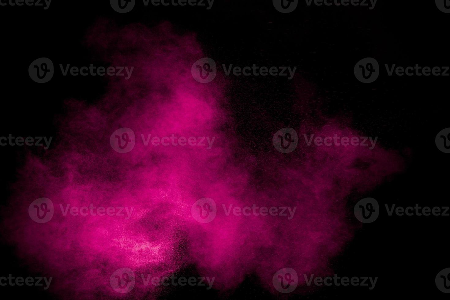 Pink dust particles splash on black background.Pink powder splash. photo