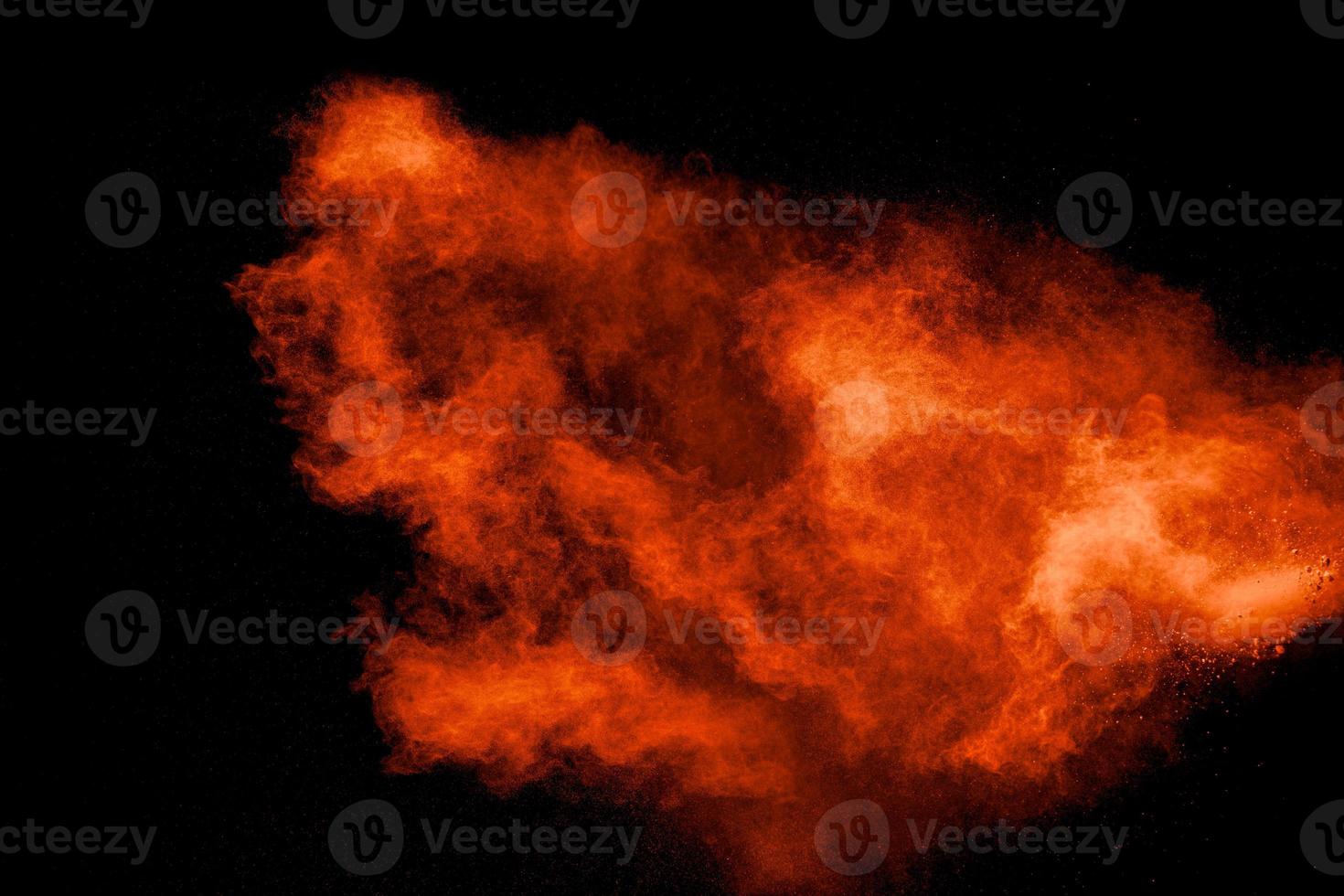 explosión abstracta de polvo naranja sobre fondo negro. movimiento congelado de explosión de polvo naranja. foto