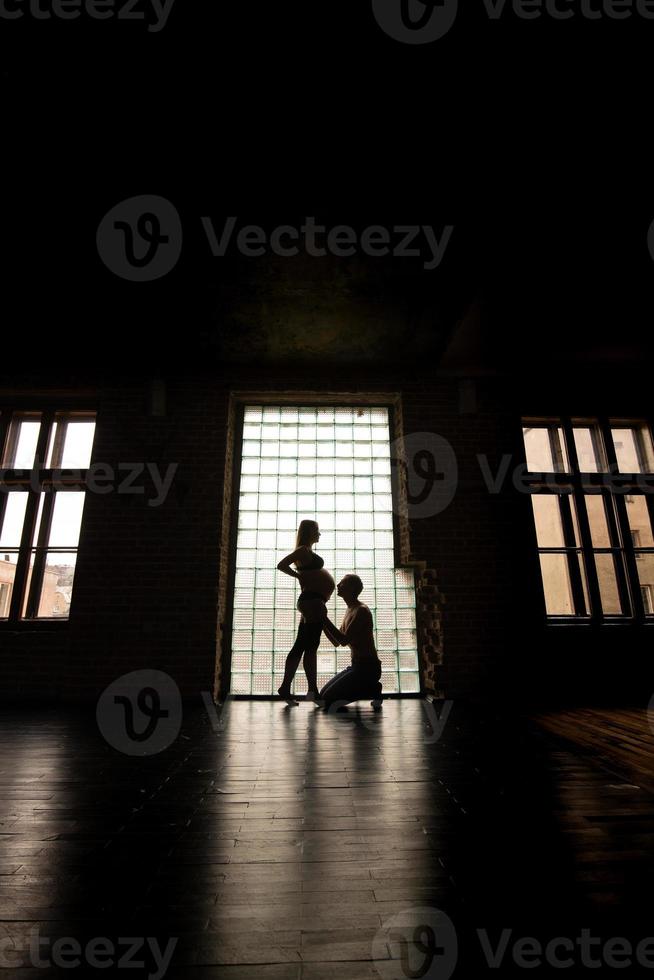 Silhouette of future parents against the window. photo