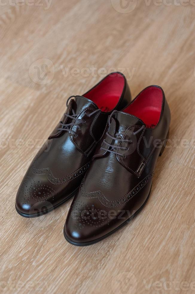 Brown shoes for men on a wooden background. photo