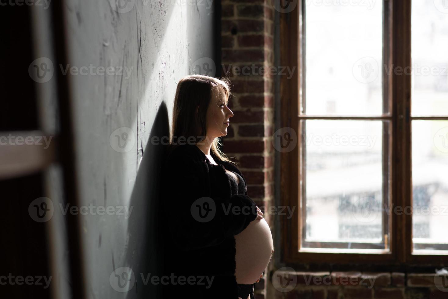 retrato de una chica embarazada cerca de la ventana foto