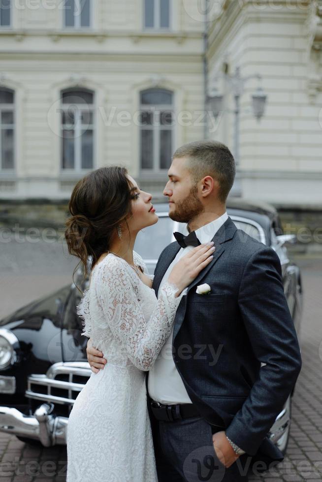 the groom in a gray suit and the bride in a gray dress look at each other, closeup portrait photo