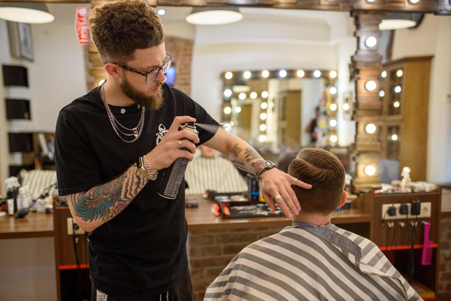 02.20.2020 Ukraine, Lviv. A barber man is styling a businessman in a barbershop photo