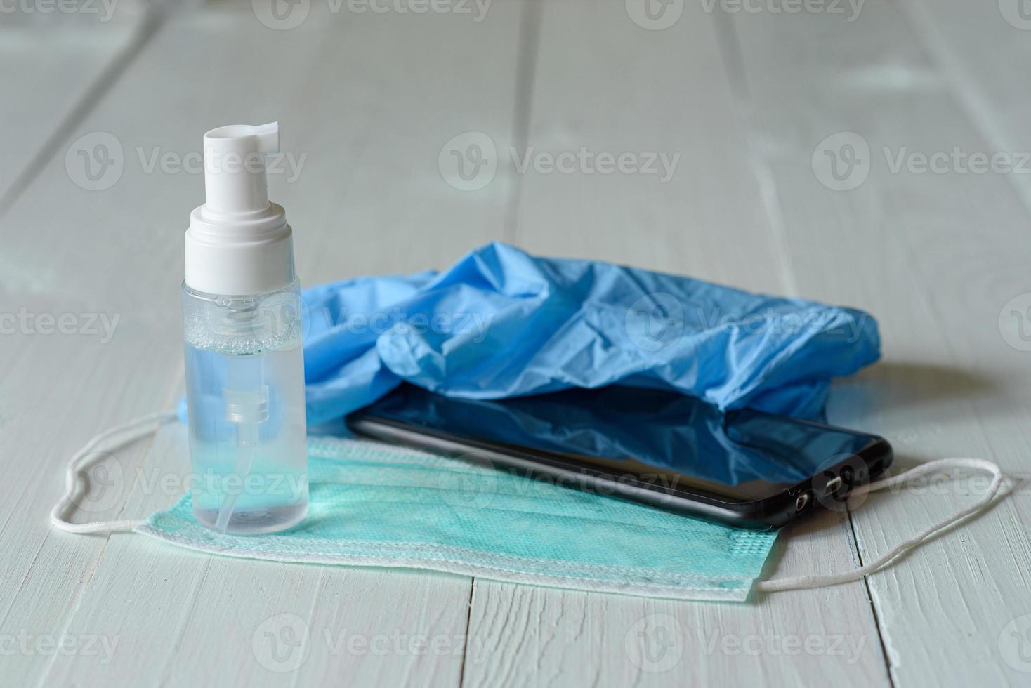 Medical gloves, antiseptic and medical mask on a white wooden background. photo