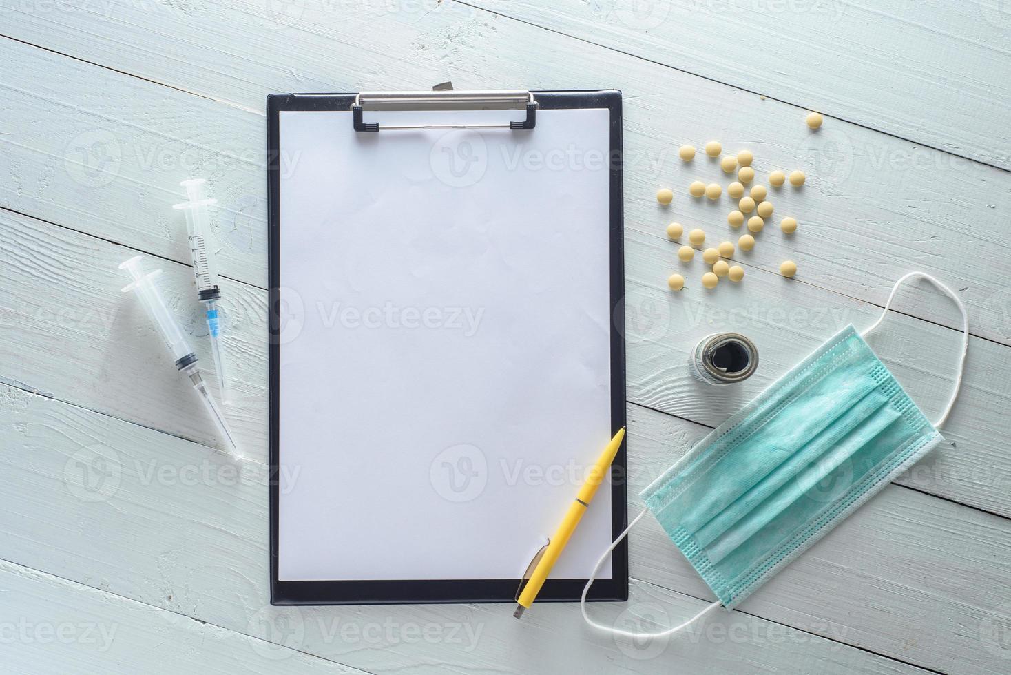 Notebook for notes, medicines, syringes. Shot on a white wooden background from above. photo