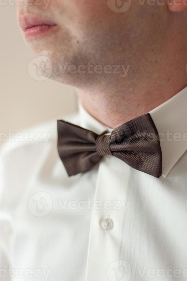 Butterfly on the neck of the groom. Close-up shot. photo