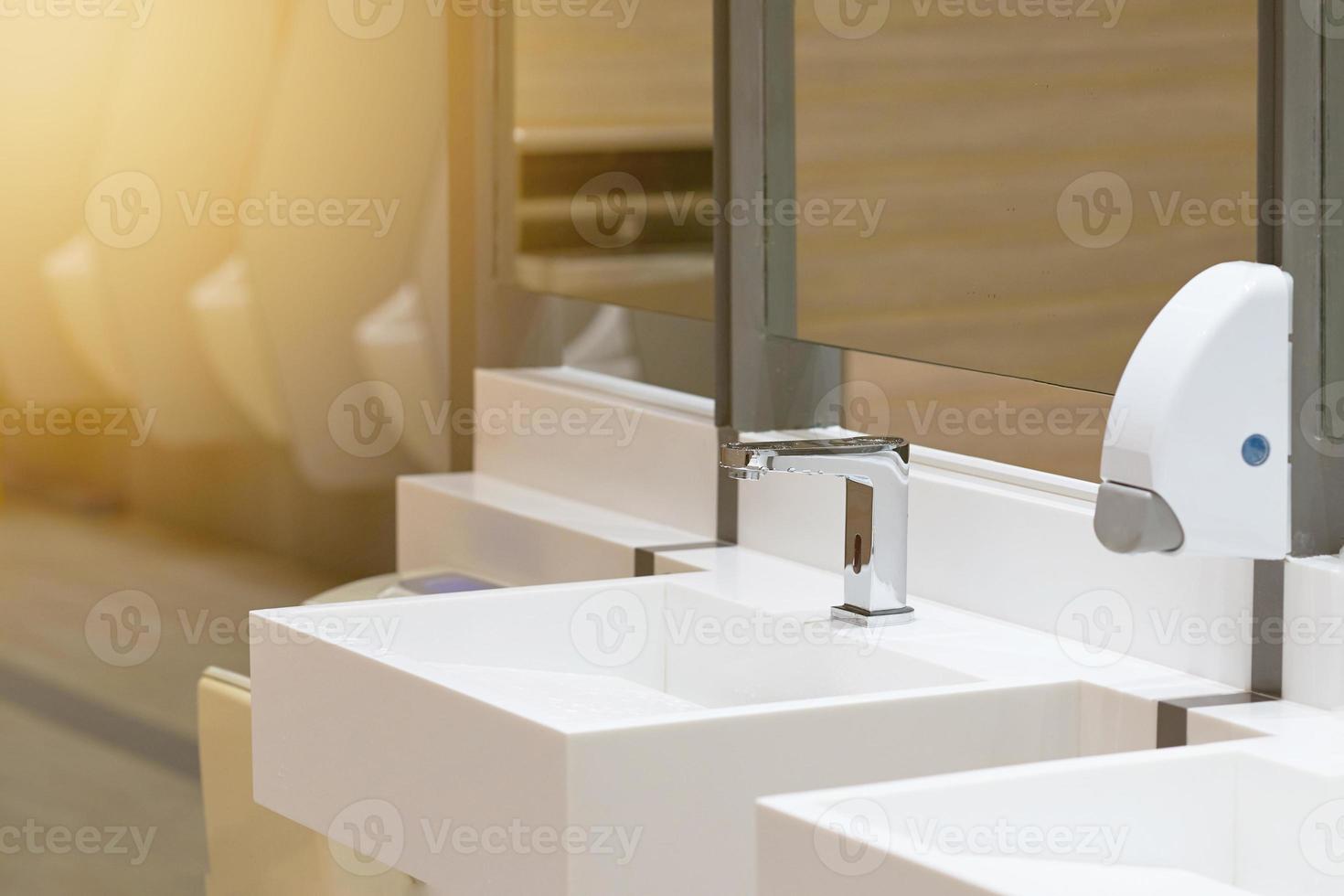 Toilet sink for wash hand with soap drop on blur urinal background photo