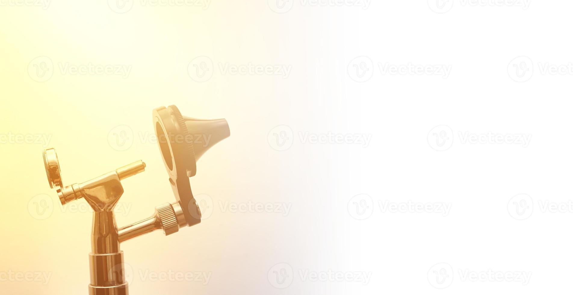 Otoscopio para otorrinolaringología examen oído cabeza pieza cónica vista sobre fondo blanco con destello de sol foto