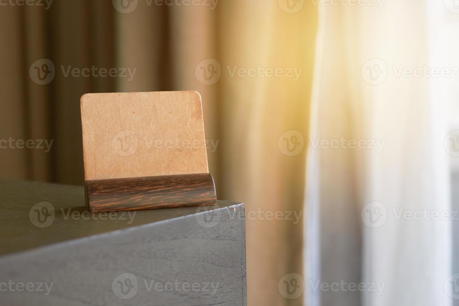 mock up vintage brown paper sign or symbol label card holder on corner of table photo