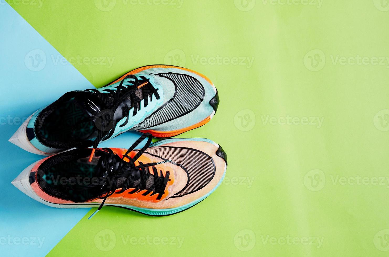 Blue and orange running shoes on green floor with copy test space photo