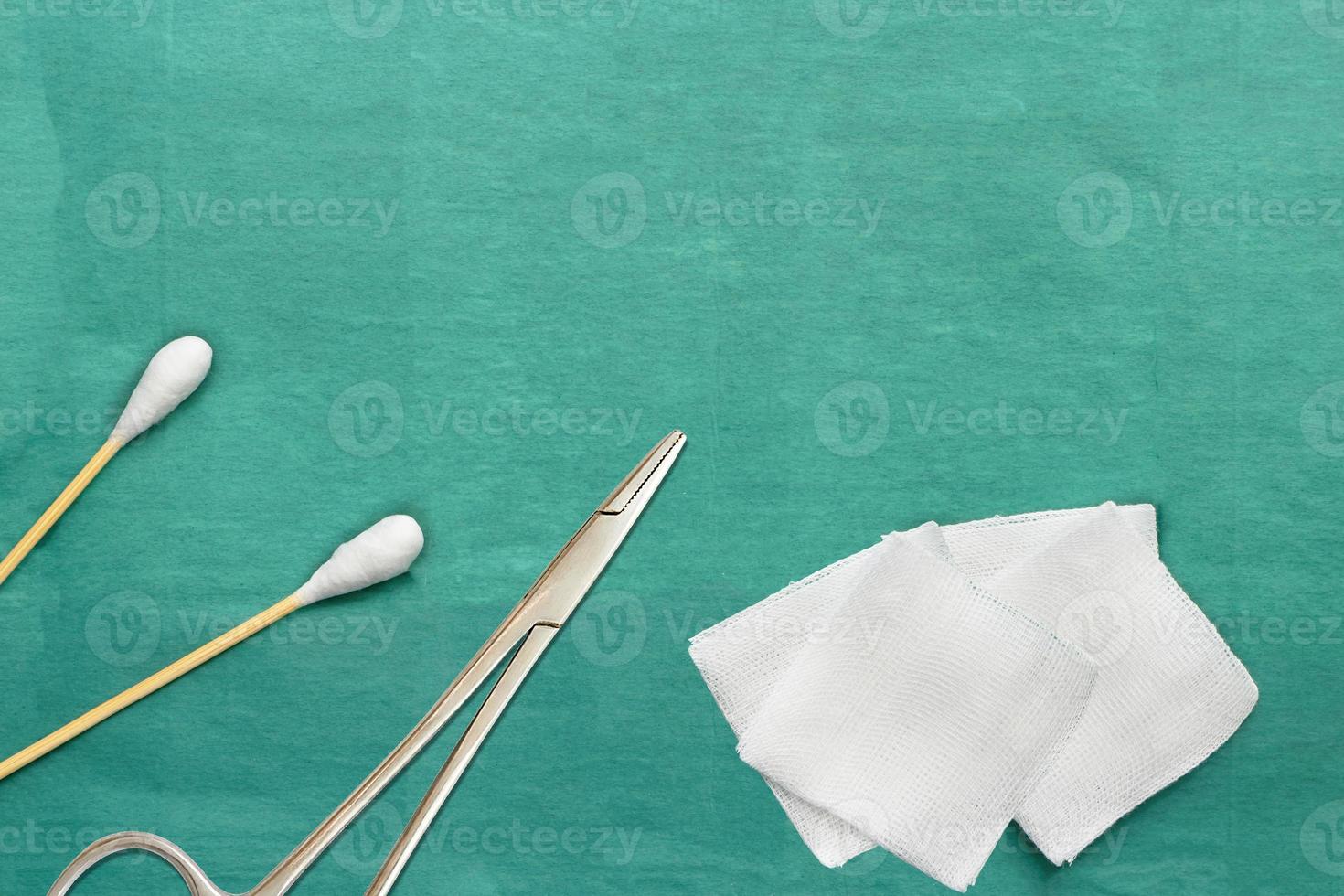 Gauze and swab cotton bus sticks on green medical surgical dress with copy space photo