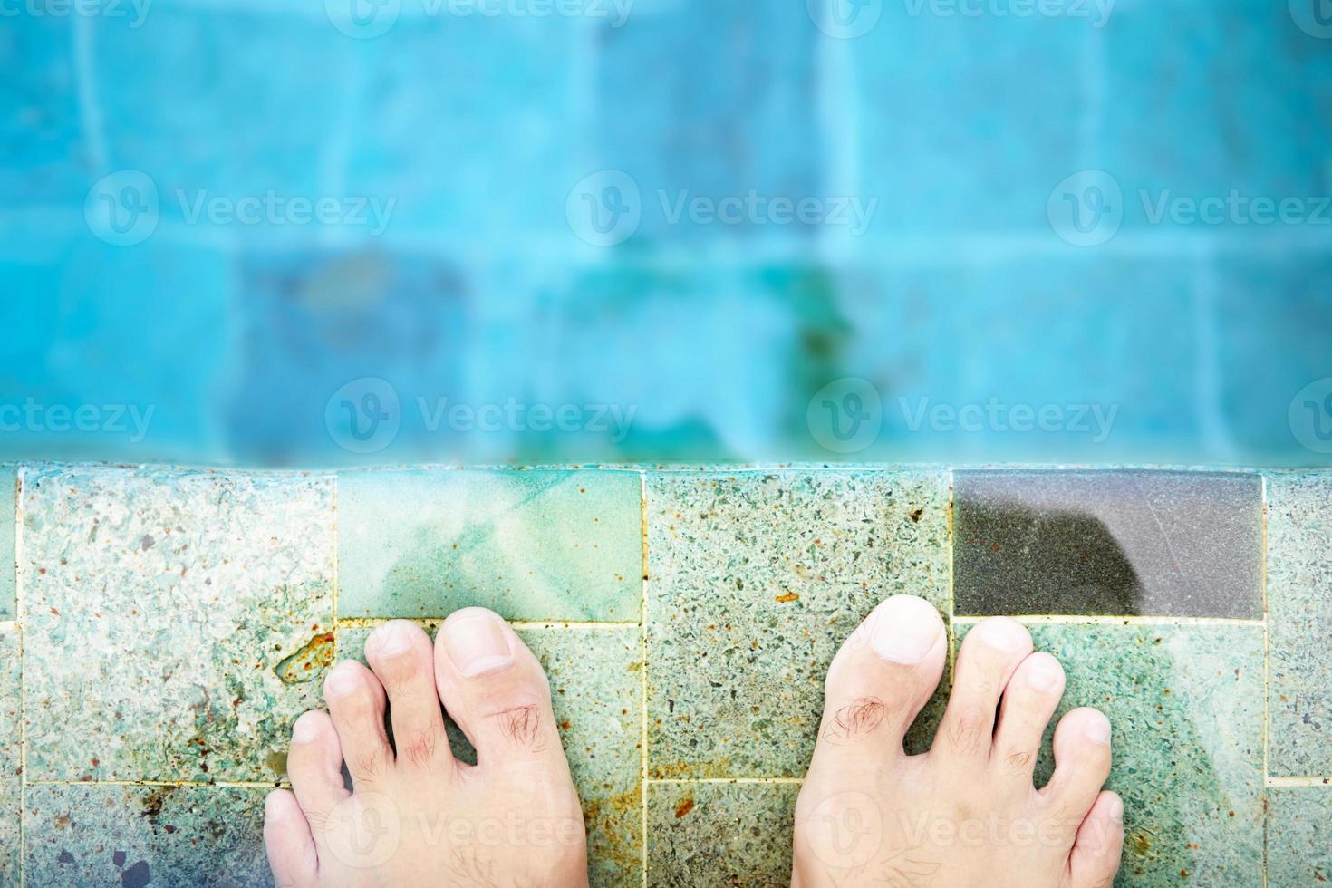 Feet and toes on poolside in vacation concept photo