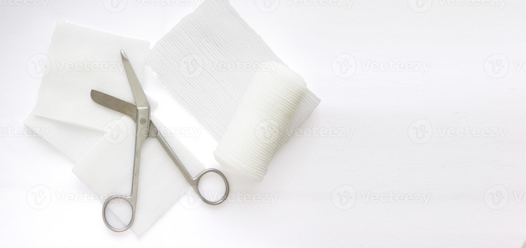 Gauzes, scissors and roll gauze on white background,closed up photo
