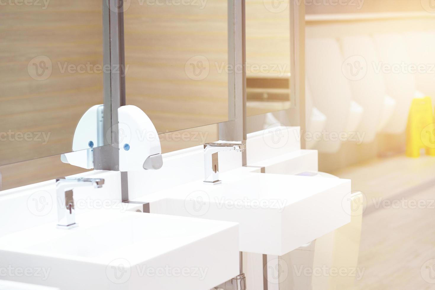 Sink in toilet with blur urinal and awareness board photo