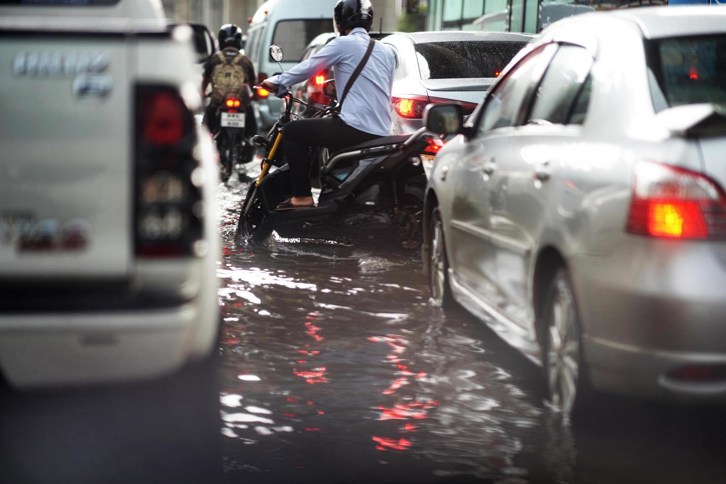 bangkok, tailandia, 16 de mayo de 2019: inundaciones en la vía pública y motocicletas y minicamiones en atascos de tráfico foto