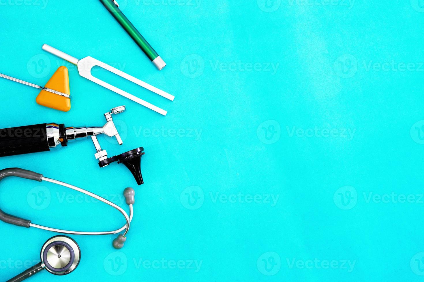 Doctor tools tuning fork,flash light,hammer jerk,otoscope and stethoscope on green surgery background with copy space photo