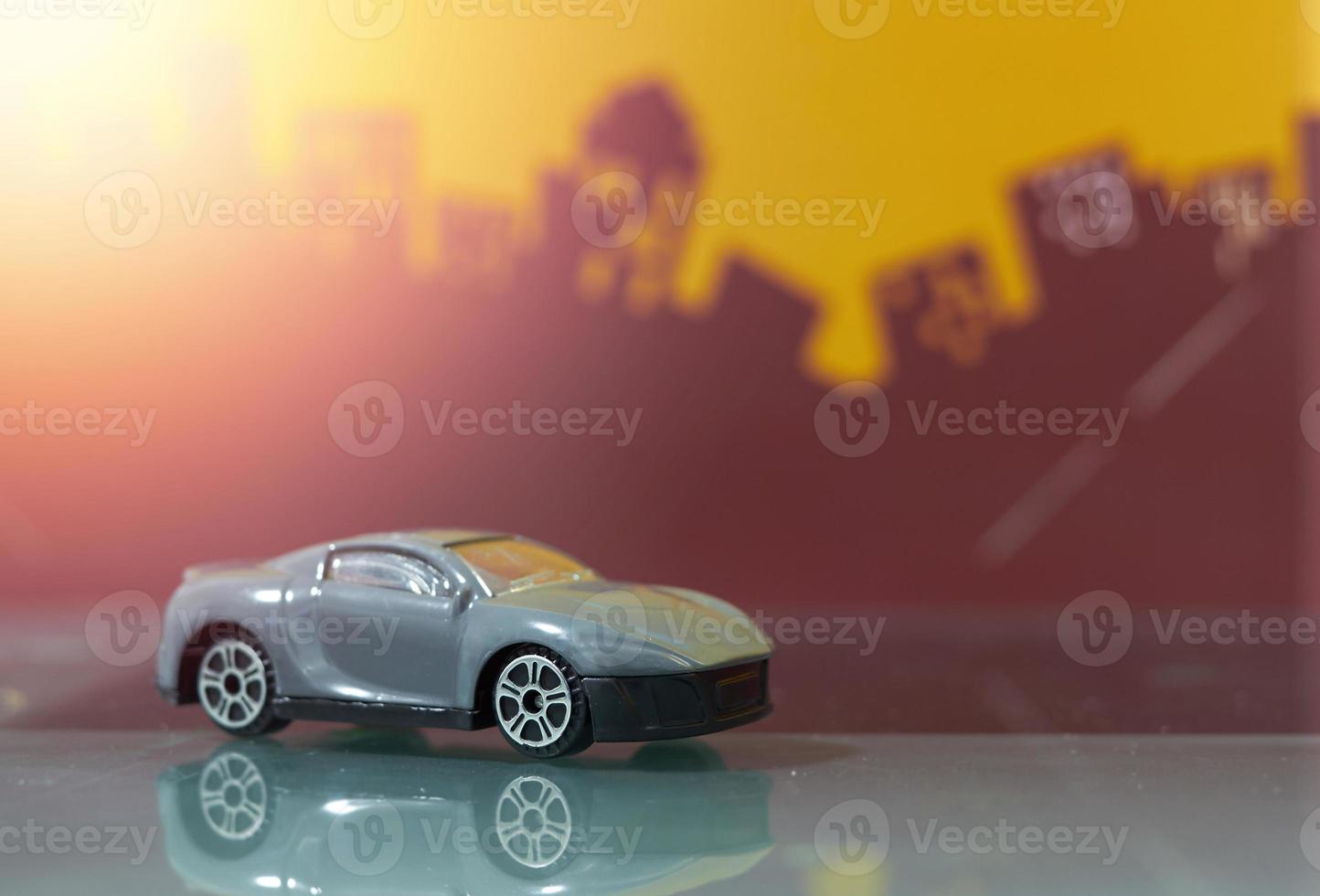 dark grey saloon car toy selective focus on blur city background photo