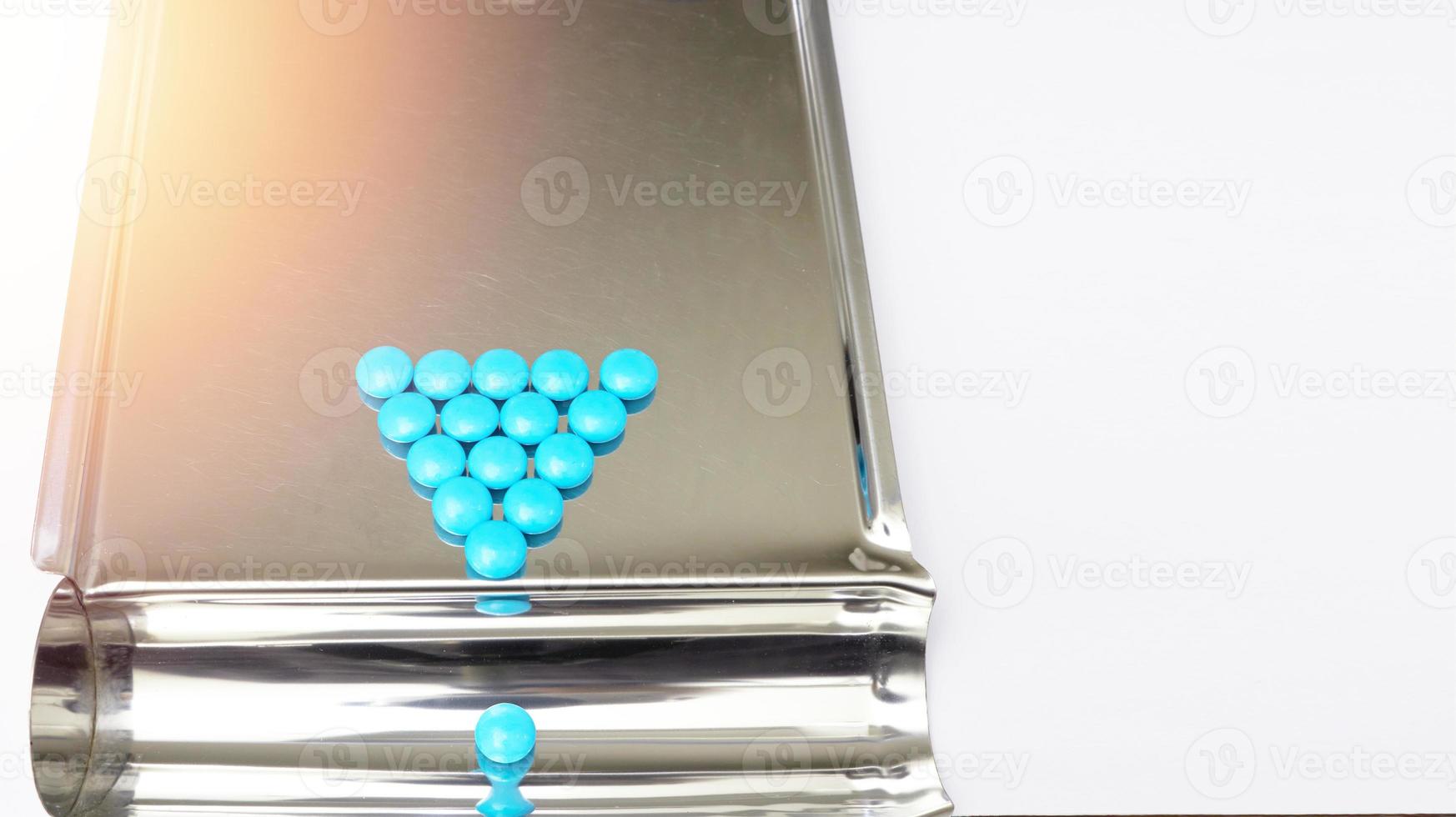 triangle arrangement blue coated tablet on tray in drugstore business and healthcare concept with copy space photo