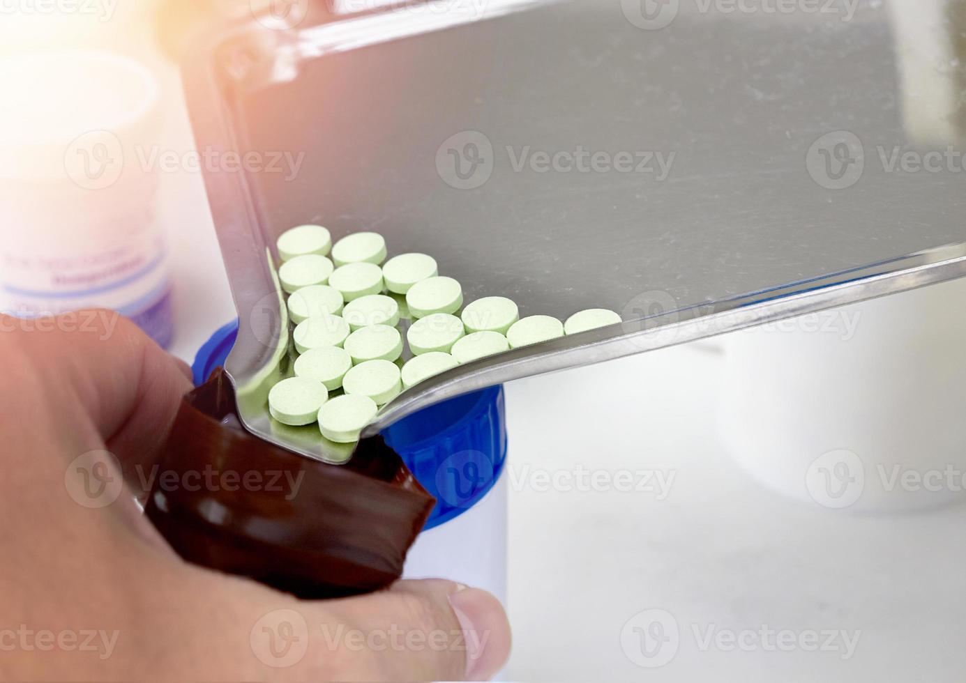 Drug pills on counting tray pour in  dark plastic zipper bag photo