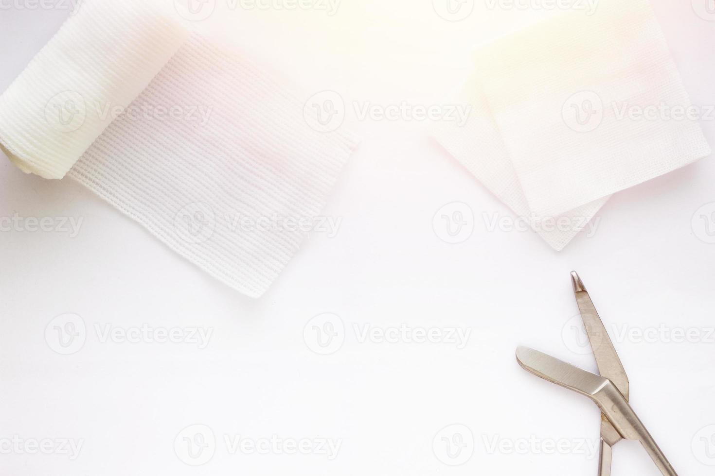 Gauzes, scissors and roll gauze on white background,top view photo