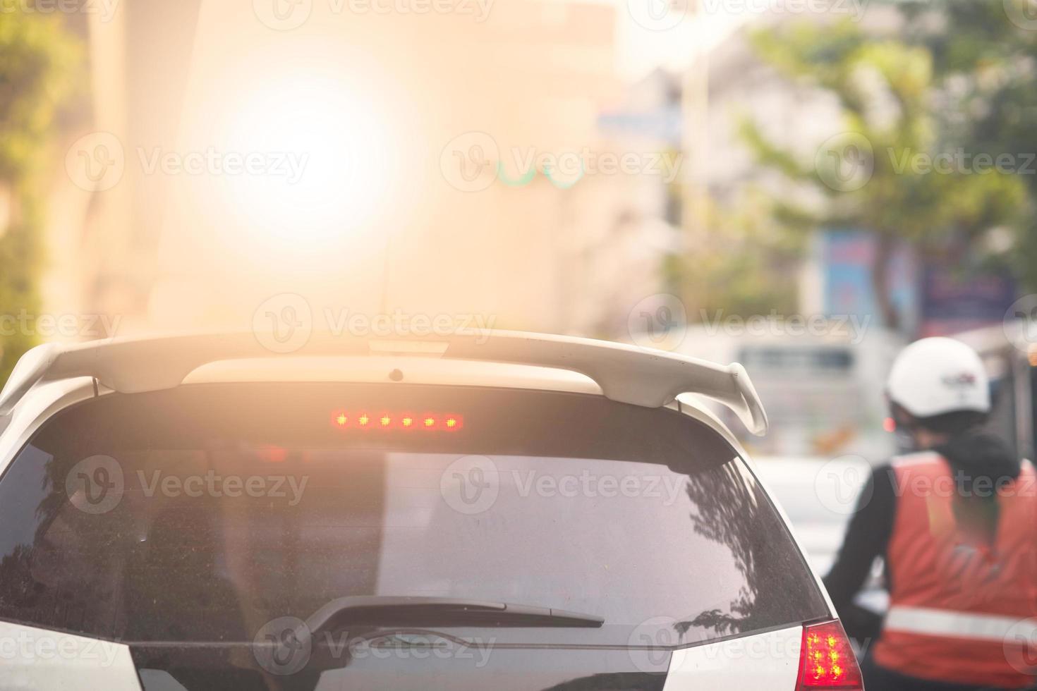 Raer view of car on street and traffic light with hired motorcycle photo
