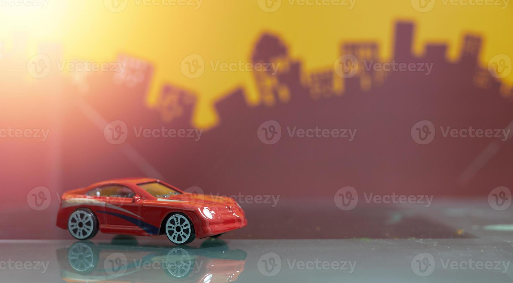 coche de salón rojo de juguete enfoque selectivo en el fondo de la ciudad borrosa foto
