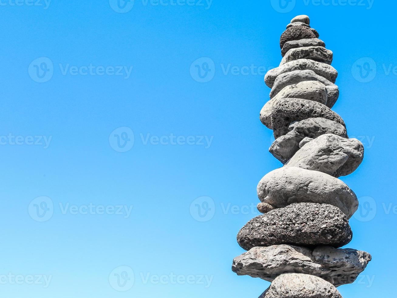 torre zen con piedras grises en equilibrio sobre el cielo azul foto