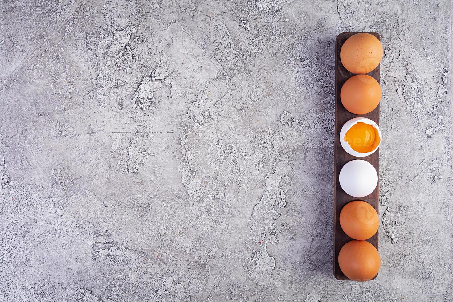 Colorful chicken eggs. Fresh chicken eggs on wooden background. Top view photo