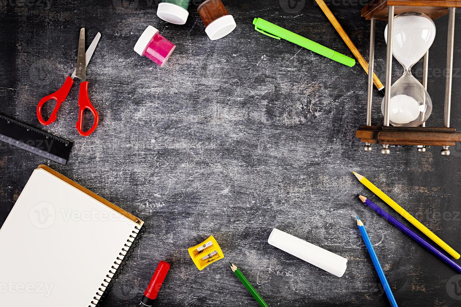 Background of dirty chalkboard. School concept with stationery supplies. photo