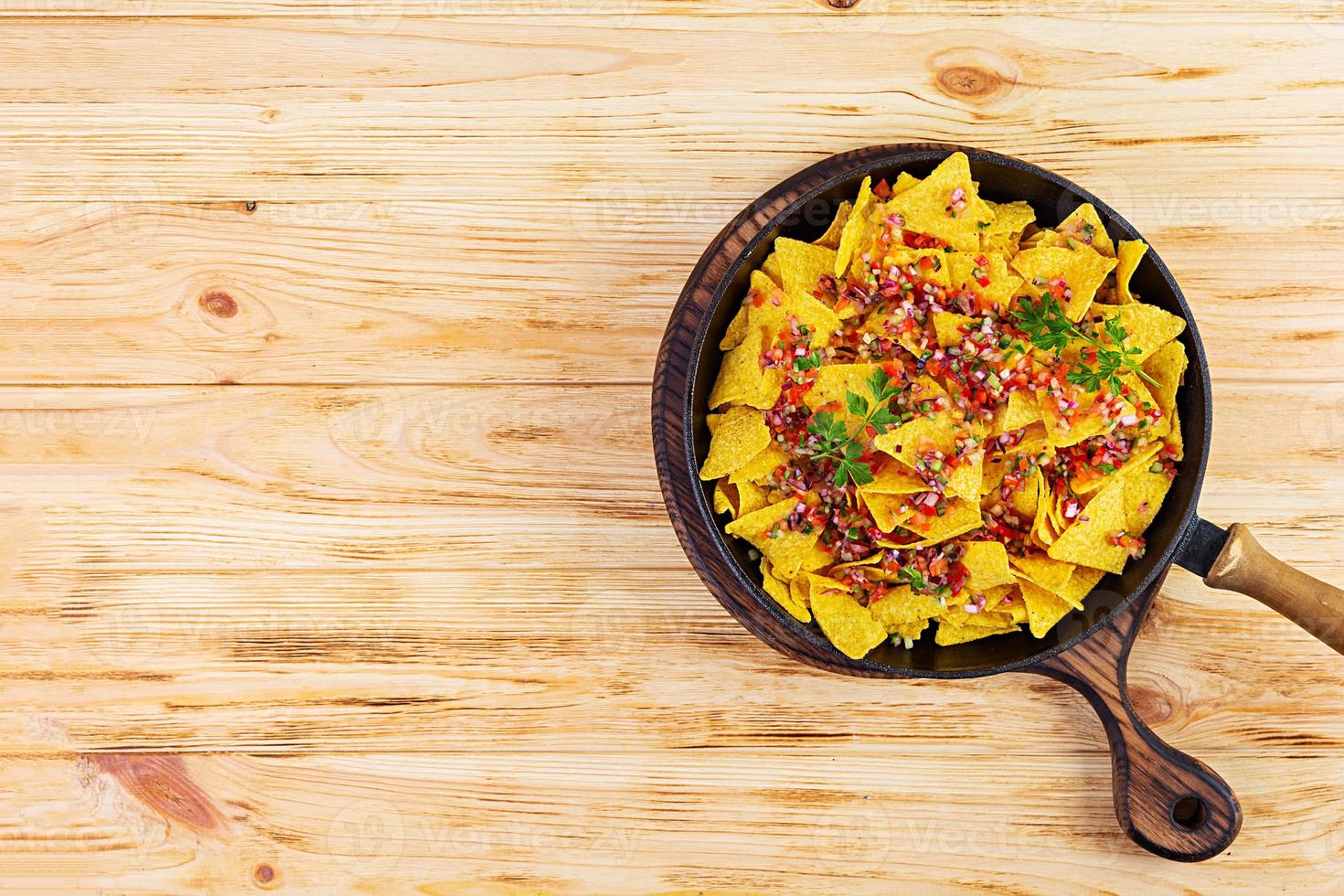 Mexican nachos with cheese. Corn chips with guacamole, salsa and tomato ketchup. photo