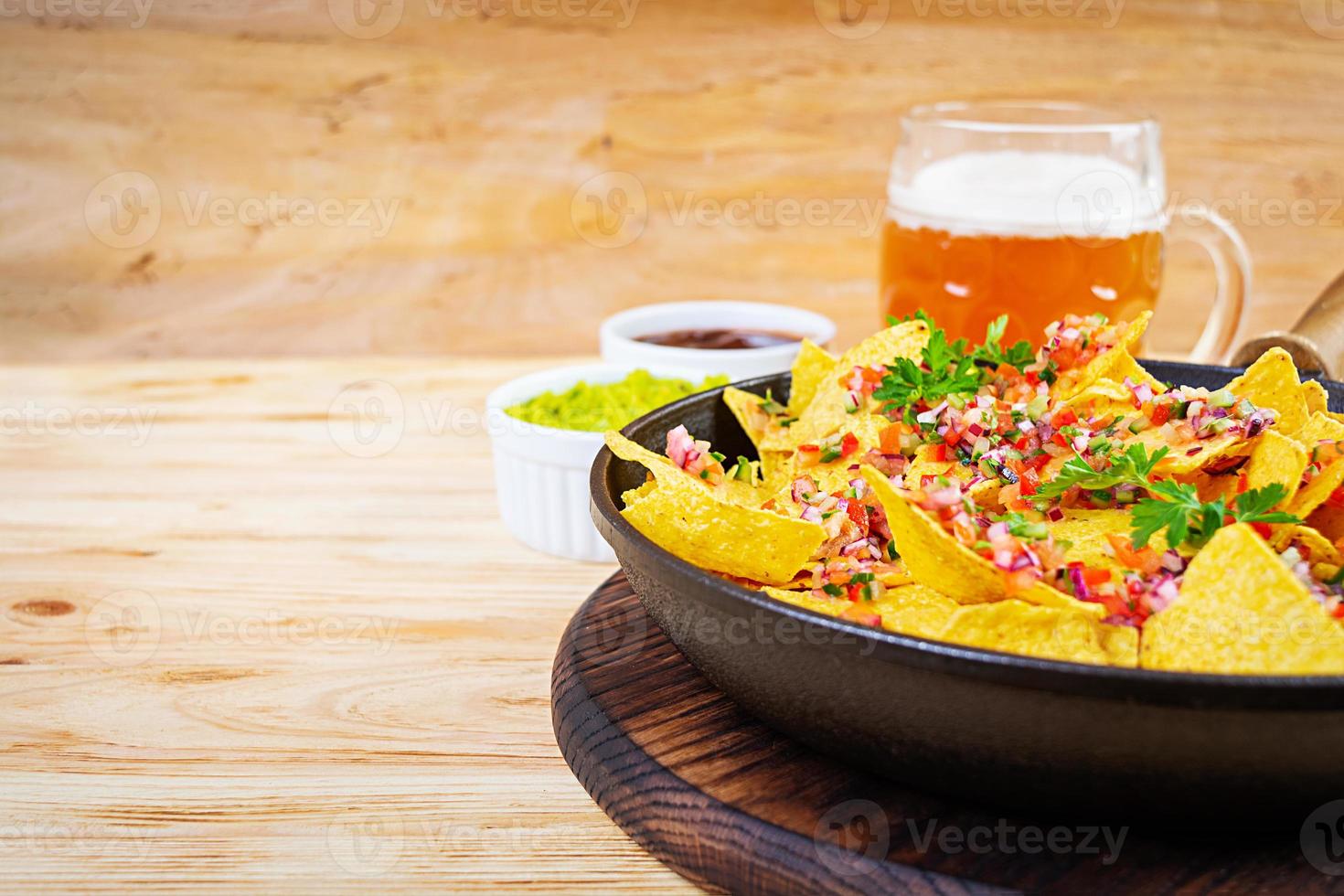 Mexican nachos with cheese. Corn chips with guacamole, salsa and tomato ketchup. photo