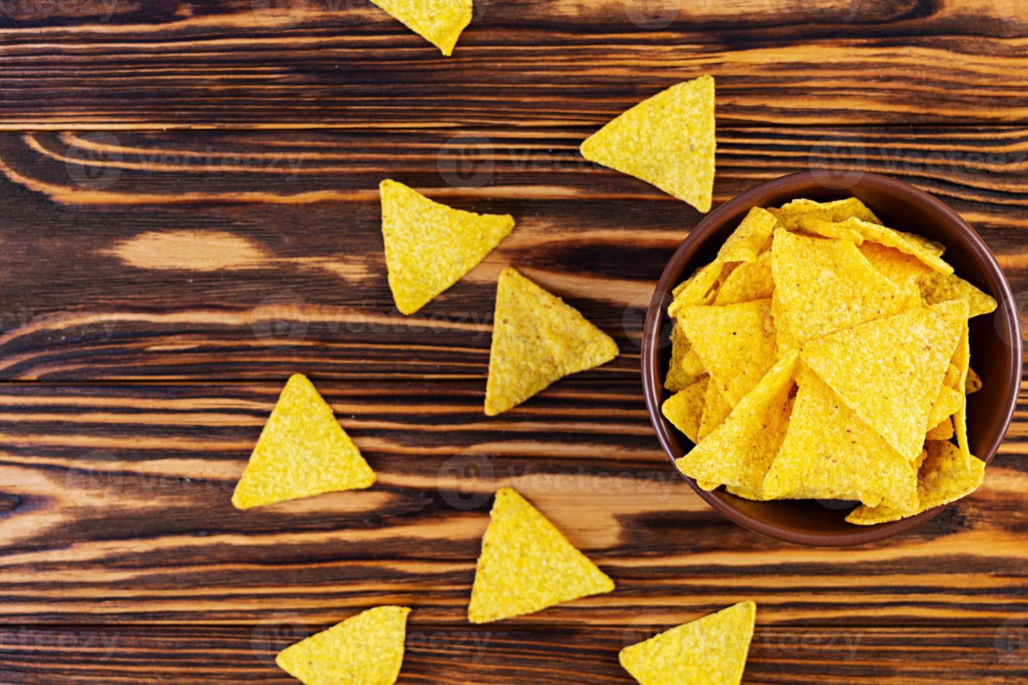 Mexican nachos with cheese. Corn chips isolated on wooden background photo
