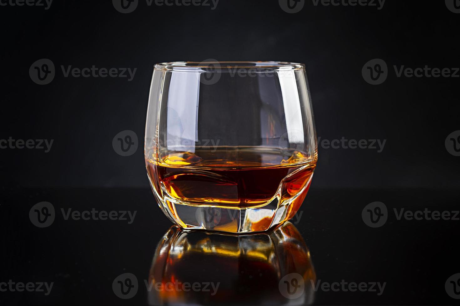 Glass of whiskey on dark background. photo