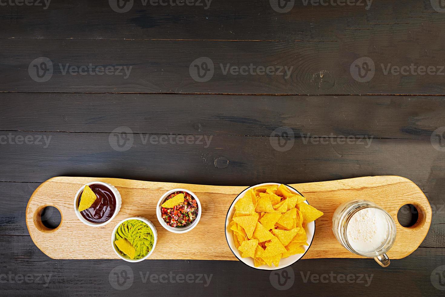 Mexican nachos with cheese. Corn chips with guacamole, salsa and tomato ketchup. photo