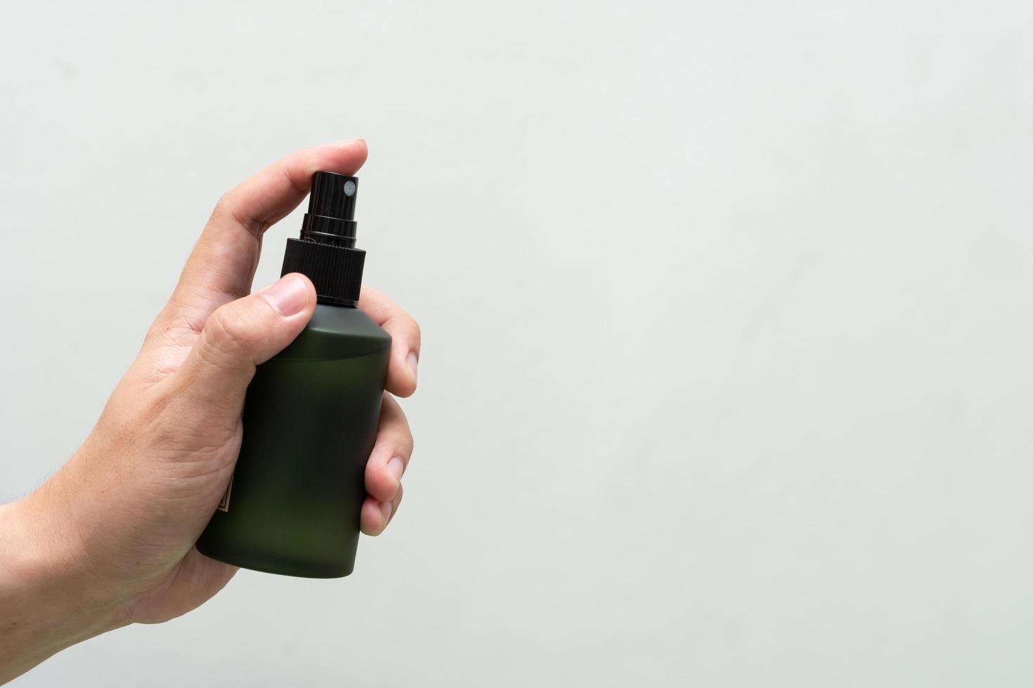 Green cosmetic bottle with label isolated on white background. Close up aroma spray bottle. Concept of organic cruelty free. Natural organic spa cosmetics concept. photo