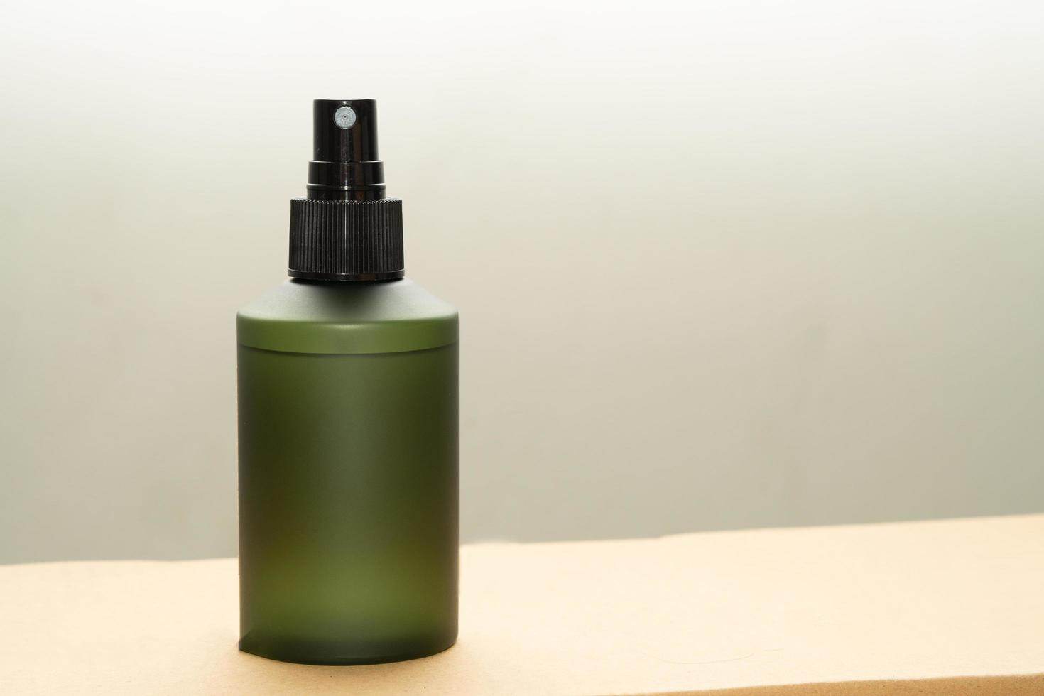 Green cosmetic bottle with label isolated on white background. Close up aroma spray bottle. Concept of organic cruelty free. Natural organic spa cosmetics concept. photo