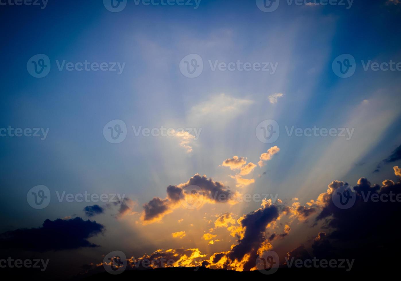 un rayo de sol se abre paso a través de la montaña y las nubes en el cielo azul, el crecimiento de la esperanza y el comienzo. foto