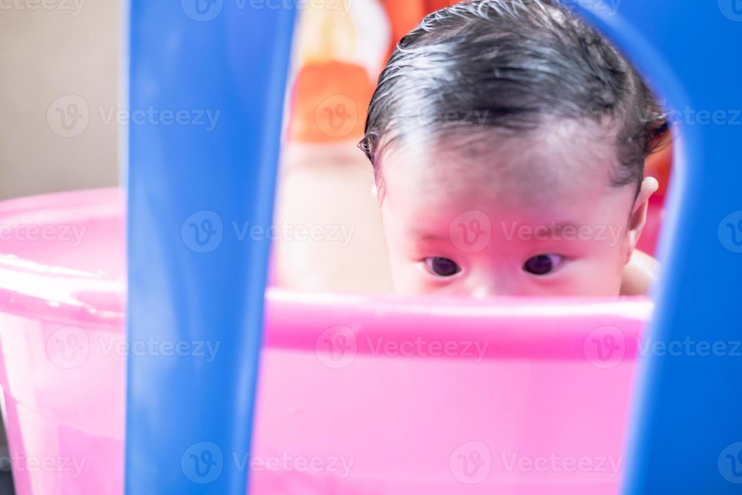 Asian mom shower baby to clean dirt give child in bath container for cleanliness lifestyle family between mother and child Used for baby shower cream products shampoos lotions and baby care product photo