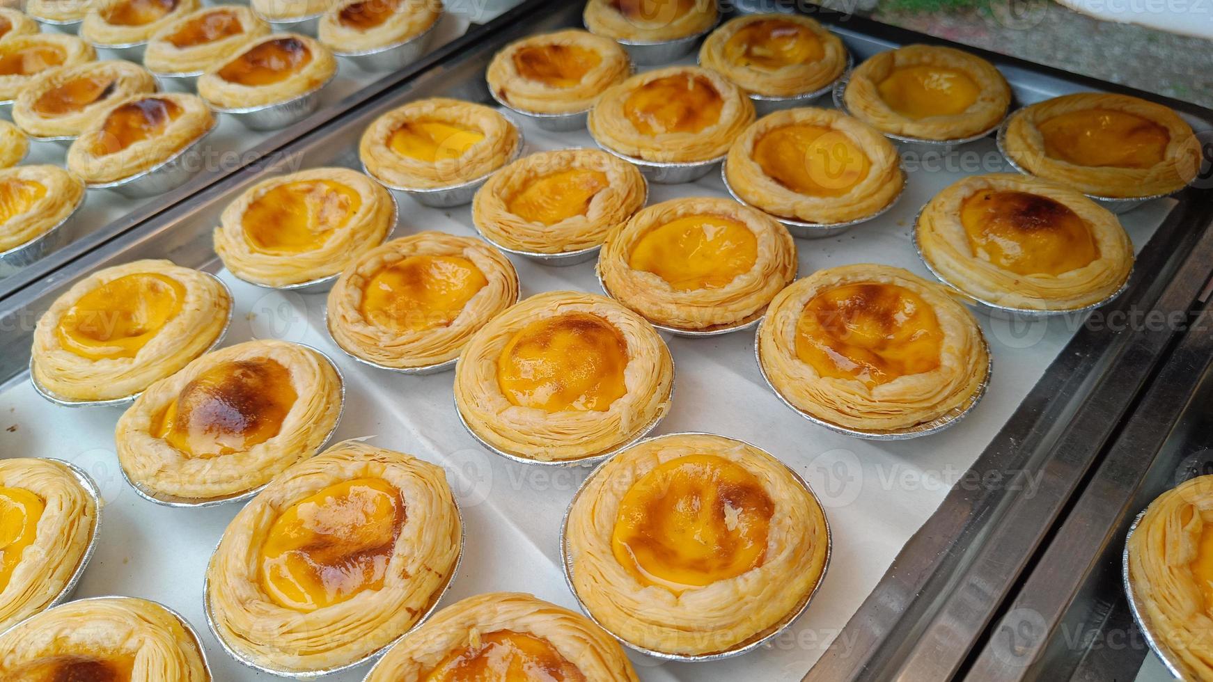 Golden brown egg tarts on a tray delicious dessert photo