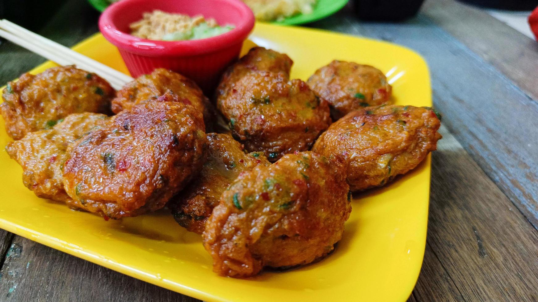 Asian food style fried fish paste balls or deep fried fish cake on a yellow plate photo