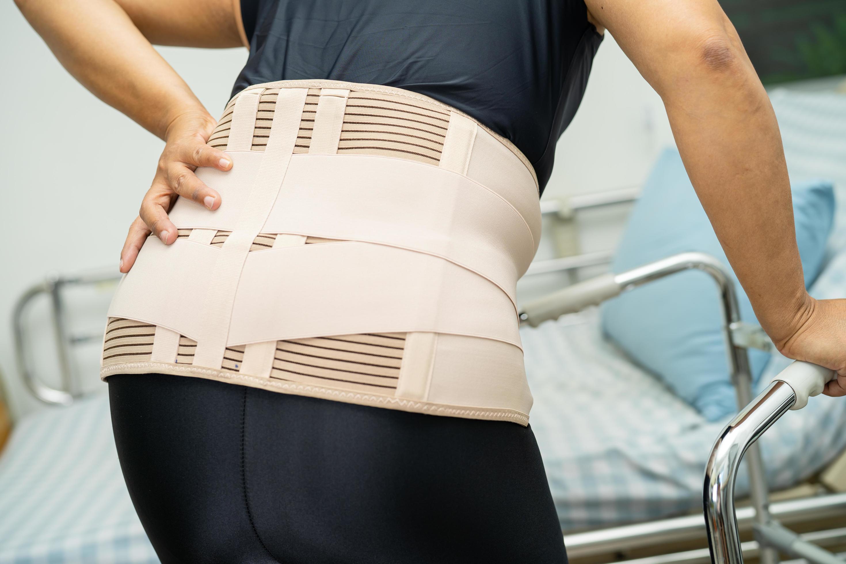 Asian lady patient wearing back pain support belt for orthopedic